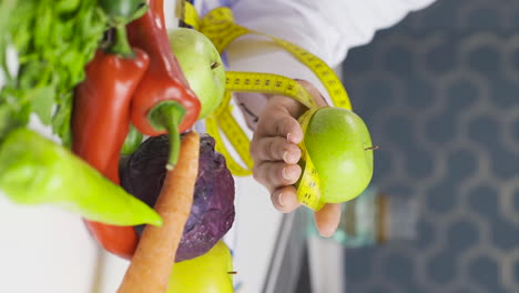 Vertical-video-of-Fruit-consumption-for-healthy-life.-The-dietitian-stretches-the-fruit.